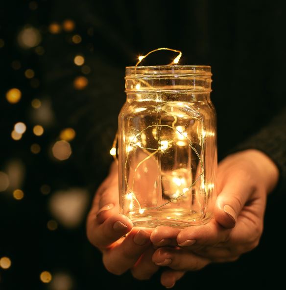Image of a wishing jar in a person's hands.