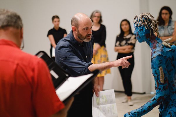 [Curator Sunny Kerr leading a tour of Tau Lewis' work.]
